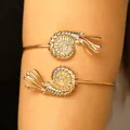 Close-up of an adjustable gold nautilus shell arm cuff for beach vacation jewelry - Conch / KC Gold