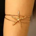Detailed view of an elegant gold starfish arm cuff perfect for a beach vacation style - Starfish / KC Gold
