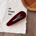 Detailaufnahme der bordeauxroten Samt-Haarklammer mit eleganter weicher Textur - Samt Rot Tropfen Stil