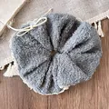 Close-up of grey plush hair scrunchie with lace trim and white button detail on fabric - Gray