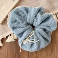 Detailed shot of a blue plush scrunchie with a white button on a cozy wooden background - Light Blue