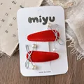 Detail of red velvet snowflake hair clips with silver bows and pearl accents on card - Bow
