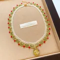 Collier de perles vert et blanc avec accents rouges et pendentif floral en résine - Collier / Vert olive