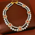 Macro view of vintage double-layered pearl necklace with rhinestone flower accents - Double-Layer Flower Pendant Style / Gray
