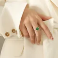Golden titanium steel open ring with green malachite stone inlay on female model - Rose Gold / Size 7 (Adjustable)