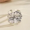 Detailed view of a silver metal cuff bracelet featuring a large wrinkled flower design. - Bangle / Silver