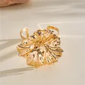 Detailed macro shot of a gold-tone oversized wrinkled flower metal cuff bracelet - Bangle / Gold