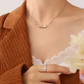 Silver twisted tube pendant necklace with geometric ring set on woman in corduroy jacket - Steel