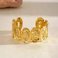 Close-up of a high-end gold-plated oval hollow geometric cuff bracelet detail. - Cuff Bracelet / Gold