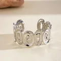 Detailed view of silver oval hollow cuff bracelet with geometric spiral texture. - Cuff Bracelet / Silver