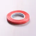 Roll of red 10m decorative balloon ribbon with textured finish for party decor - Red