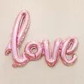 Detailed view of pink metallic LOVE foil balloon for wedding and party decorations - Pink