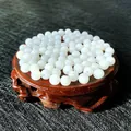 Polished white cat-eye crystal beads for DIY jewelry making displayed on a wooden base - Opal White