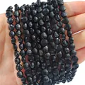 Faceted black natural stone beads for DIY bracelets shown held in hand for scale - 6mm Diameter 4mm Thickness 1mm Hole 38cm Strand Approx 60 Beads / Natural Black Onyx