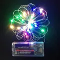 Close-up of multicolored LED copper wire string lights with battery pack on dark leather - Copper Wire Light / Colorful