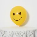 Detail of yellow latex balloon with winking smiley face print and white holder stand - Yellow Winking Smiley