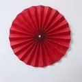 Detailed view of a red pleated paper fan flower with center pearl for wedding decor - Small / Red
