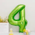 Detail of a large number 4 fruit green foil balloon with a happy birthday party hat - Number 4