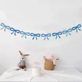 Detail of blue felt bow garland hanging on a white wall for birthday party decor - Blue Bow