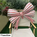Close-up of a large red and white striped bow balloon measuring 77x63cm on a chair - Striped Bowknot (White Base) / 77cmx63cm