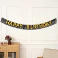 Detalle de banner Happy Birthday con letras doradas sobre fondo de flecos negros decor - Negro