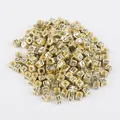 Close-up of golden cube alphabet beads with black engraved letters for jewelry making - Cyrillic Alphabet Style (BSD355) / 100 Pieces/Pack (6x6mm) / Antique Gold