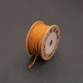 Handmade twisted cotton cord in ginger yellow on a kraft paper spool for DIY crafts - Earthy Yellow