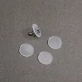 Transparent silicone piercing pads with stud earring on grey textured background - Diameter Fourteen