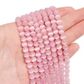 Primo piano di perle rosa occhio di gatto per gioielli fai da te in mano - 6mm Rosa (1 Filo/Confezione, circa 65 pezzi)