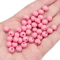 Perline rotonde in legno rosa per gioielli fai-da-te mostrate in mano per scala - 8mm (Foro Circa 2mm) / 50 Pezzi / Rosa scuro