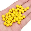 Perline di legno giallo 8mm per gioielli fai-da-te mostrate in mano per scala - 8mm (Foro Circa 2mm) / 50 Pezzi / Giallo chiaro