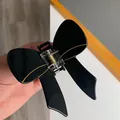 Eleganter schwarzer Acetat-Schmetterlings-Haarclip mit Goldakzenten für stilvolles Haar - Schwarz