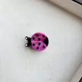 Pink ladybug resin hair clip with marble texture and black dots on fabric background - Pink Ladybug