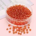 Polished 4mm amber glass beads for DIY necklaces stored in a small clear round container - Orange & Yellow