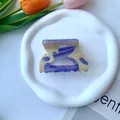 Macro view of purple marble acetate flower hair claw clip on a white ceramic tray - 8*5CM / Beige & Blue