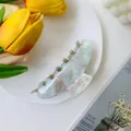 Close-up of a large blue acetate hair claw with marble texture and floral pattern - Large / Light Ink Green