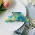 Close-up of large blue and gold marble textured acetate hair claw clip for women - Aqua Green Colorful