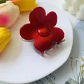 Macro shot of a red floral shark hair claw clip on a white plate with tulips - Red Grey Patchwork