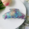Close-up of a large iridescent acetate hair claw clip with colorful aurora texture - Holographic Blue