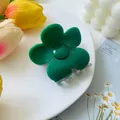 Detailed view of a green flower claw clip placed on a white porcelain plate with tulips - Green & Grey