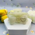 Cream bow hair claw clip made of acetate with a sparkling rhinestone heart detail - Heart Mermaid Pearl