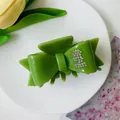 Avocado green bow hair claw clip with rhinestone L-letter accent and glossy finish - Grass Green