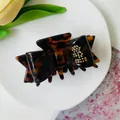 Tortoiseshell acetate bow hair claw clip with gold stud accents and high-gloss finish - Red-Brown Tortoiseshell
