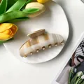 Dettaglio di una molletta per capelli a scacchi beige su un piatto bianco con tulipani - Scacchiera Beige