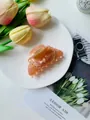 Eleganter Haarklammer aus Acetat in Bernstein-Rosa mit Goldfeder auf Keramiktablett - Orange