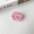Dettaglio ravvicinato della pinza per capelli rosa con decorazione a occhiali a cuore - Piccola Rosa Dimensioni 45*35 Cm