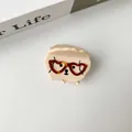 Dettaglio di molletta per capelli a cucciolo con occhiali a cuore rossi e finitura lucida - Cane Piccolo Beige Occhiali Cuore