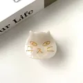 Macro view of white cat hair claw made of acetate with elegant gold face details - Pearl White