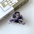 Detailed view of French-style acetate hair claw clip with purple marble bow design - Iridescent Purple