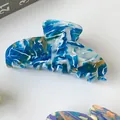 Detailed view of the marbled blue and gold acetate hair claw clip on white background - Teal